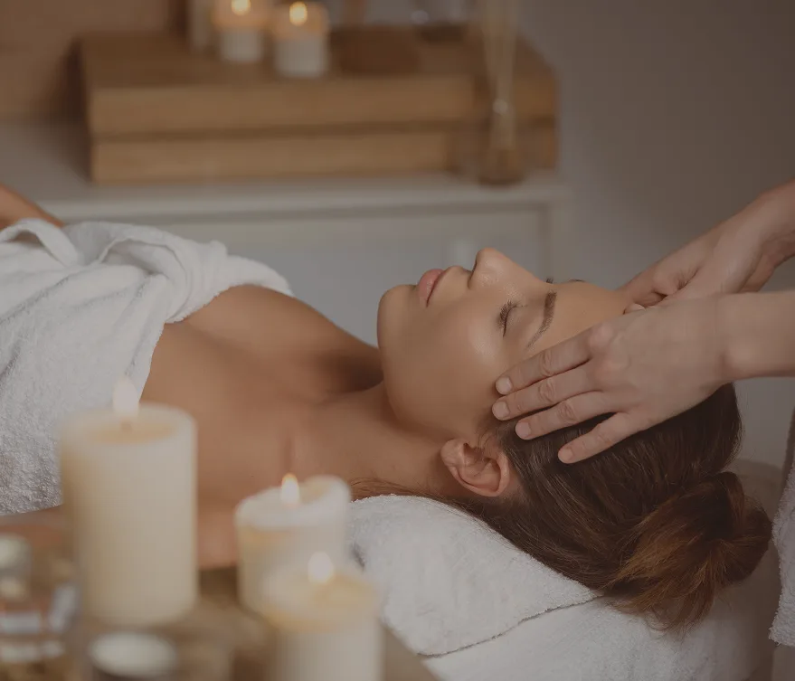 Kobieta relaksująca się podczas masażu w strefie SPA Treesna, otoczona świecami i spokojną atmosferą.