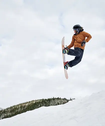 Snowboardzista wykonujący skok w powietrzu na stoku – sporty zimowe w okolicy TREESNA Kombi Invest